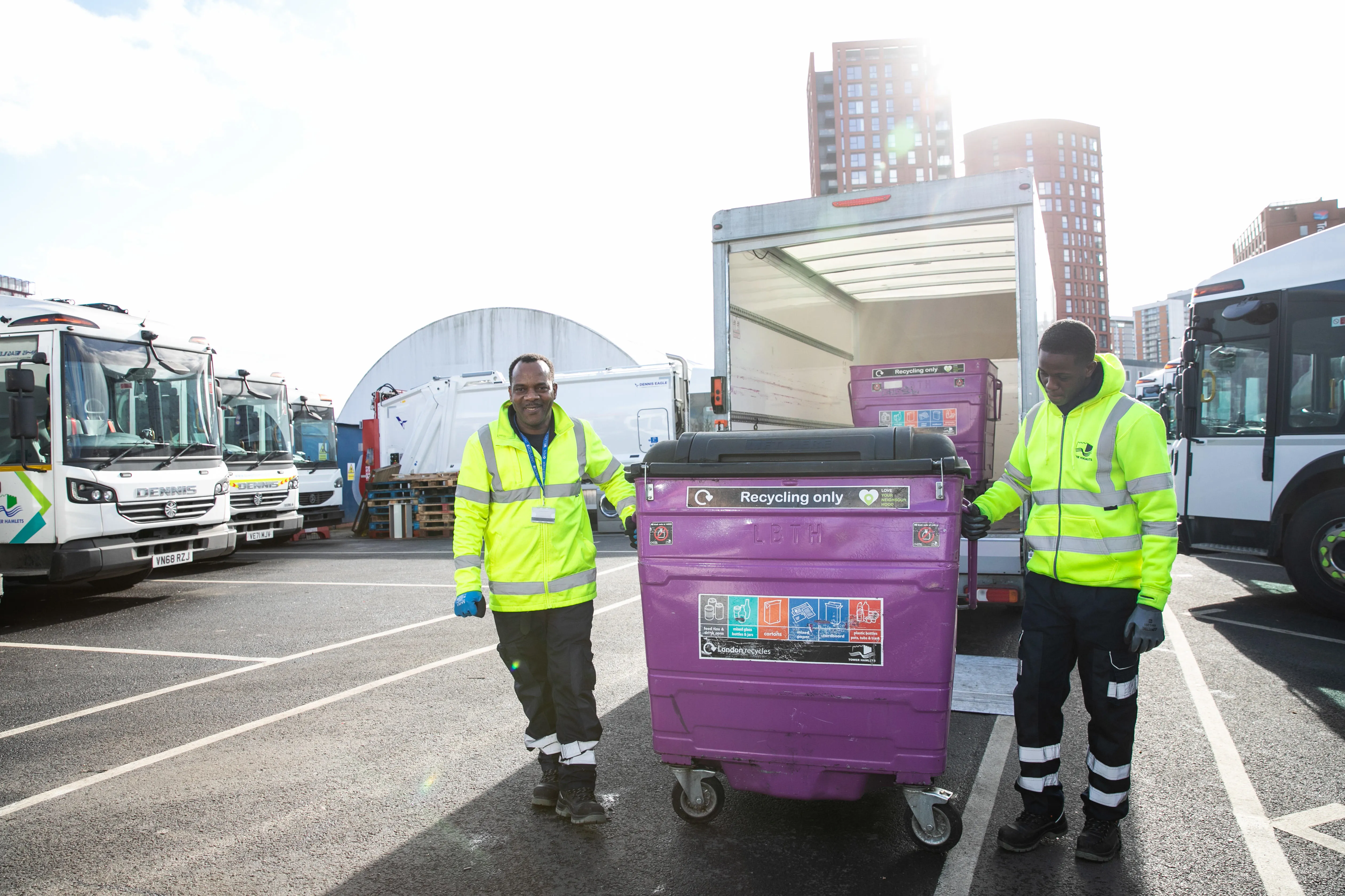 Two waste officers with a purple recycling bin